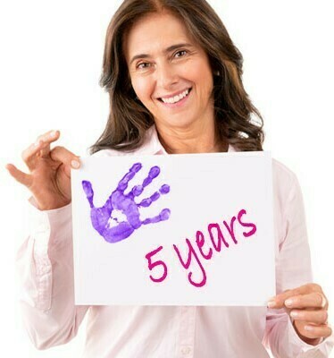 Woman holding sign with handprint celebrating 5 years.