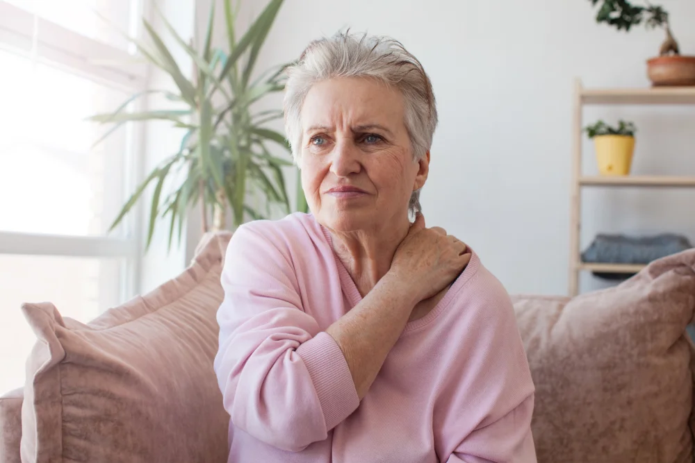 Senior woman with shoulder pain at home.